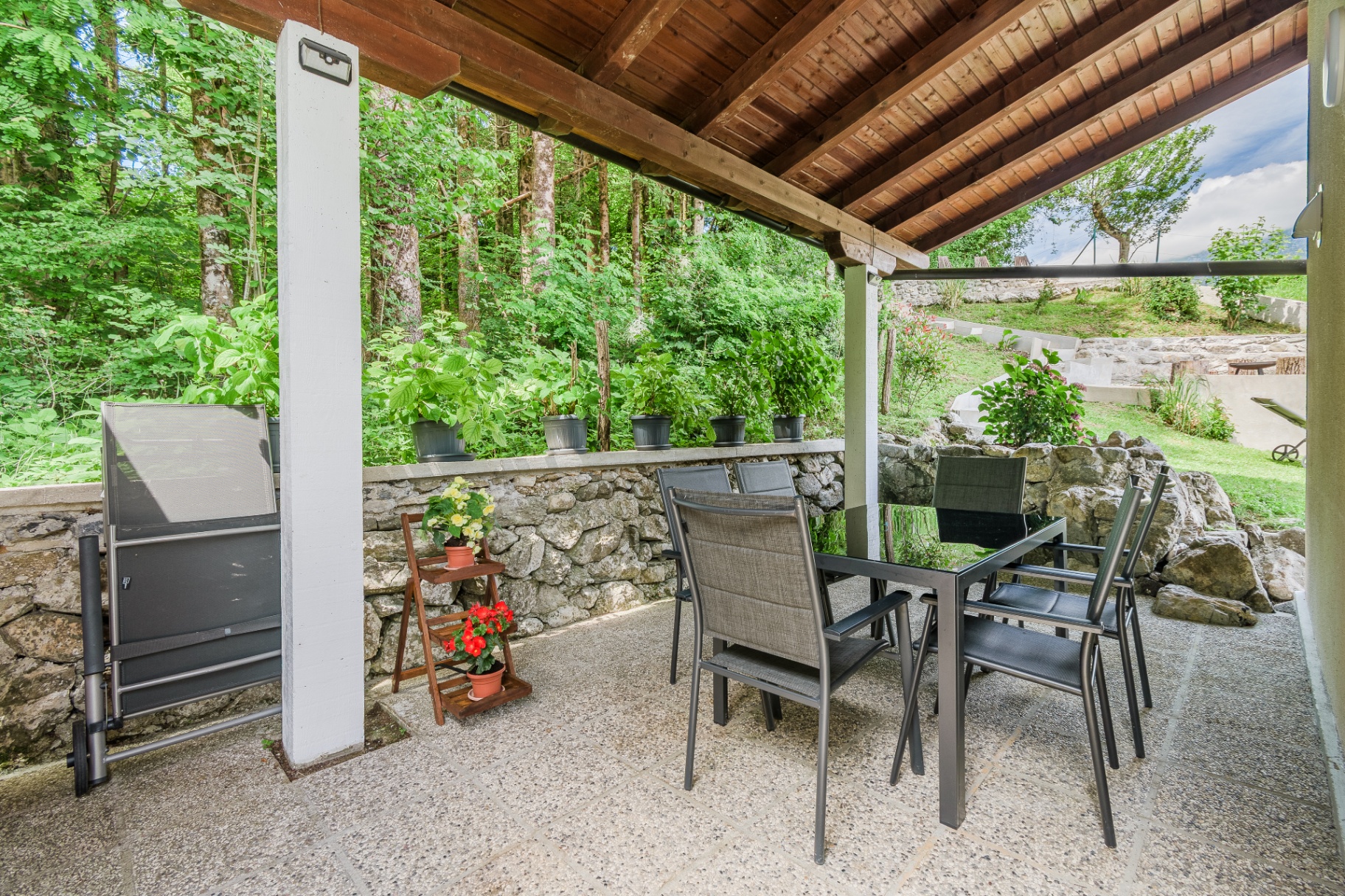 Pokrita terasa počitniške hiše Cottage Kobarid z mizo in stoli