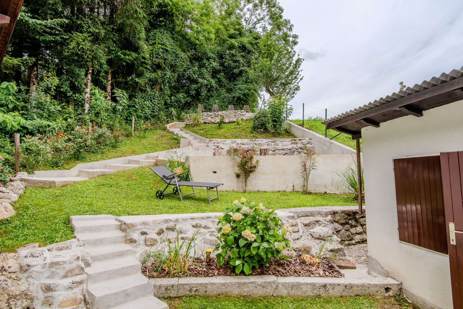 Zgornja vrtna terasa počitniške hiše Kobarid z ležalnikom in stopnicami